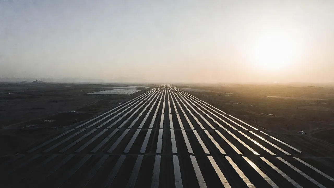 Aerial view of a utility-scale solar farm stretching to the horizon at sunrise